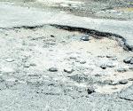 Tapan baches con escombro
